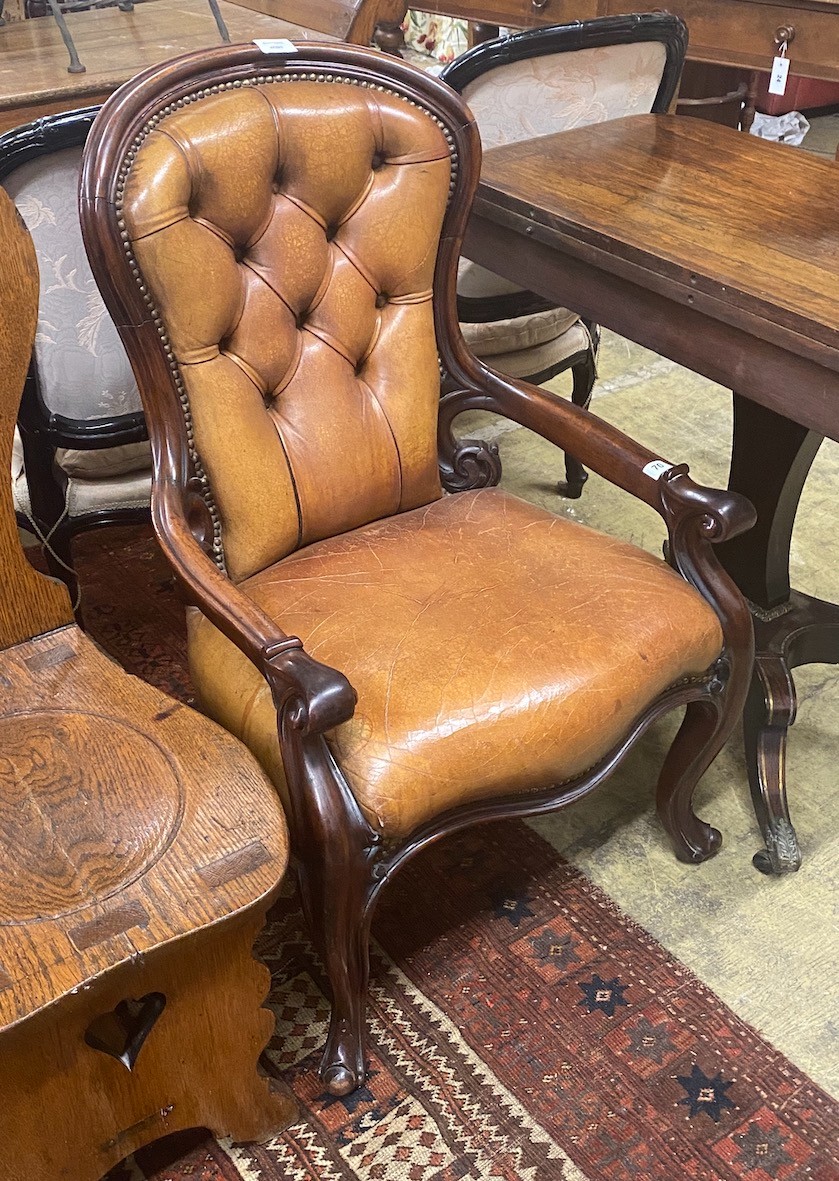 An early Victorian mahogany open armchair upholstered in tan leather, width 60cm, depth 42cm, height 94cm